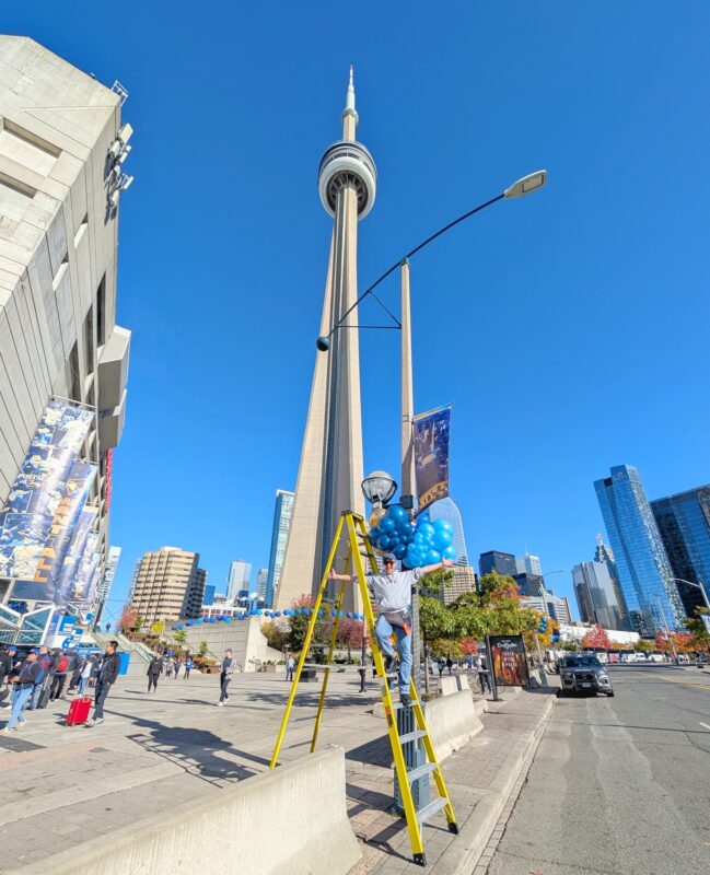 Pawel Rzeznik working high above the street on a balloon installation near the CN Tower.
