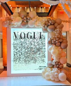 Silver shimmer wall photo backdrop rental in Kitchener Waterloo with white, champagne, and metallic balloon garland, modern illuminated display, and custom signage for anniversary celebrations.