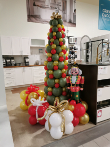 A Christmas tree surrounded by presents, all made with balloons.