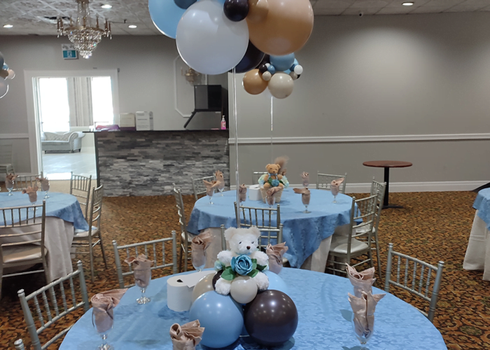 A bear themed centrepiece with a cluster of balloons suspended overtop to create a cloud.