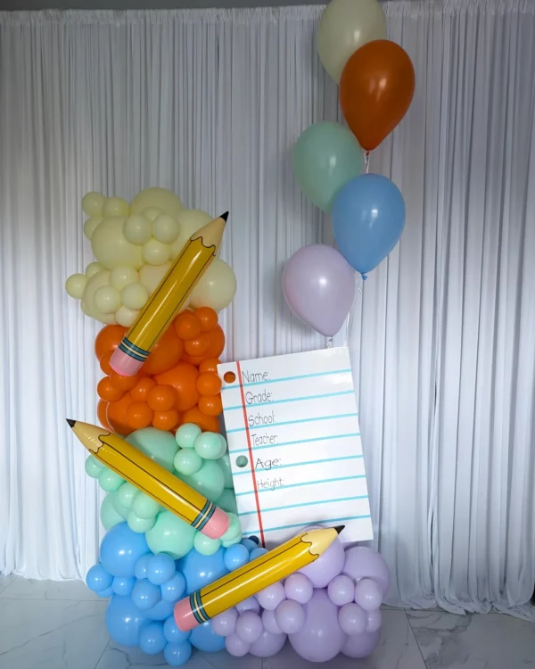 Brightly colored balloon display featuring large pencils and a blank form for student information, ideal for school-themed events.