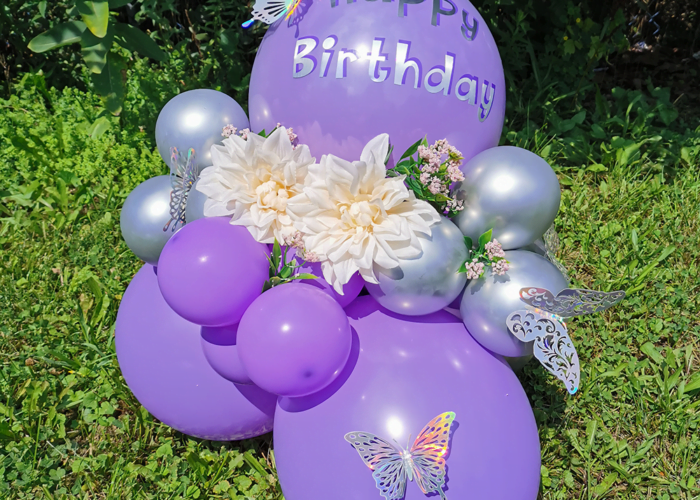 Purple balloon bouquet on grass.