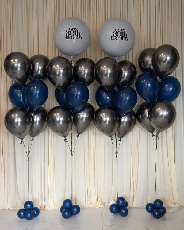 A festive balloon arrangement featuring silver, blue, and two large "Happy 30th Birthday" balloons against a cream backdrop.