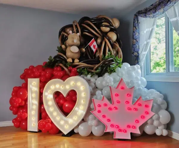 Colorful balloon display featuring "I ❤️ Canada" lights, a Canadian flag, and a balloon beaver in a festive setting.