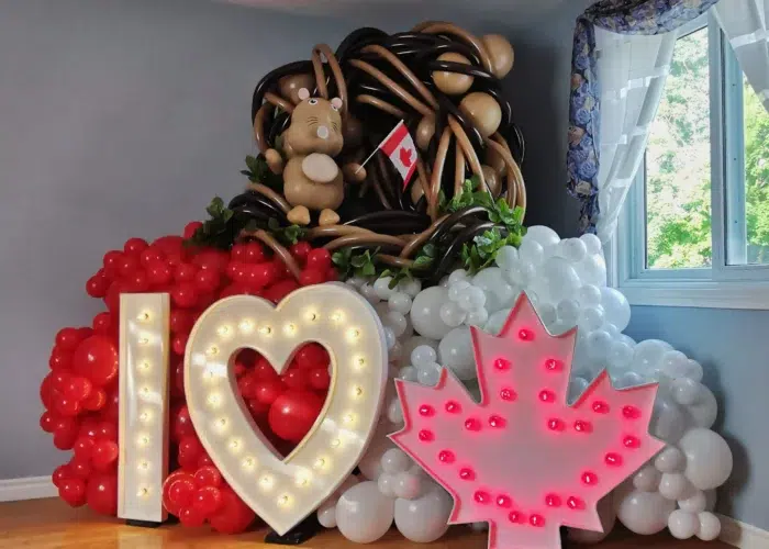 Colorful balloon display featuring "I ❤️ Canada" lights, a Canadian flag, and a balloon beaver in a festive setting.