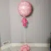 A large pink 24-inch helium balloon with a custom message, featuring a tassel tail and balloon base.