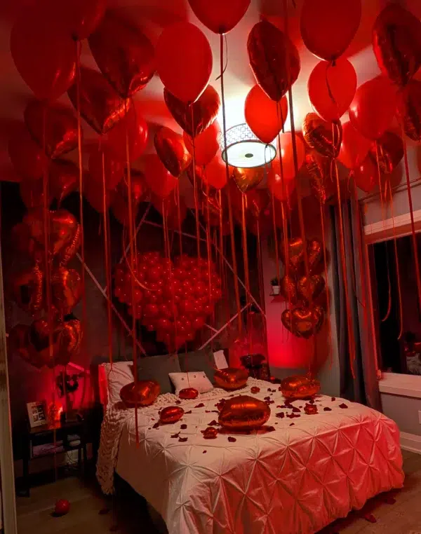 A romantic bedroom filled with red balloons and heart-shaped decorations, creating a festive and cozy atmosphere.