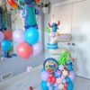 Stitch-themed balloon bouquet and number stack featuring tropical decorations, customizable colours, and personalized decals in a vibrant party setup.