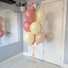 Elegant Mother’s Day bouquet with blush and cream latex balloons and a floral heart-shaped foil balloon, tied to a soft yellow water weight.