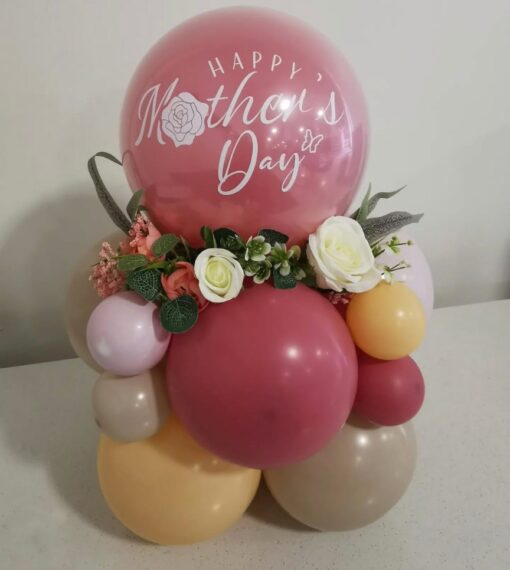 Mother's Day balloon arrangement with pastel-coloured balloons, artificial floral accents, and a personalized decal reading "Happy Mother's Day".