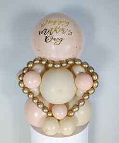 Balloon display with cream, blush, and gold balloons, metallic gold mini garland, and a personalized large balloon topper.