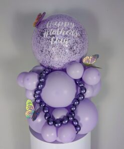 Lilac and lavender balloon display with large speckled balloon, metallic mini garland, and butterfly decorations.