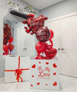 Large white Valentine’s Day box with red hearts releasing helium heart balloons that float upward when opened.