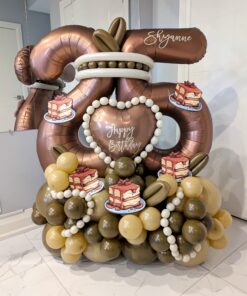 Tiramisu themed balloon number stack with mocha coloured foil balloon, dessert accents, cream and caramel balloon base, and personalized name decal. 🍰