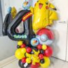 Pokémon themed balloon number stack with Pikachu balloons, Poké Ball accents, red yellow and black balloons, and personalized name decal. ⚡