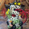 Farm themed balloon number stack with cow print balloon, tractor topper, corn balloons, and green organic balloon base for a barnyard birthday party.