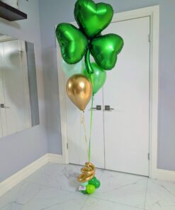 Emerald shamrock heart helium balloon bouquet with green and gold latex balloons and gold spiral base detail.