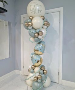 Pastel Easter balloon column with pearl white, blue, and gold balloons, featuring egg balloons and a “Happy Easter” topper.