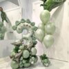 Dinosaur themed balloon setup with sage green number stack, helium bouquet, metallic dinosaur balloons, and personalized name decal
