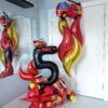 Fire truck themed balloon setup with red and black number stack, flame balloons, helium bouquet, and personalized name decal