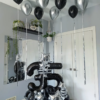 Black and silver balloon number stack with star accents and helium balloons with tassels for a modern birthday setup