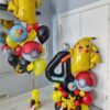 Pokémon themed balloon setup with yellow, red, and black number stack, helium bouquet, Pikachu balloons, and personalized name decal