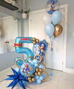 Sonic themed balloon setup with blue and gold number stack, helium bouquet, character balloons, and personalized name decal