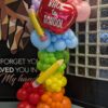 Colourful back-to-school organic balloon column with red apple and oversized pencil balloons.
