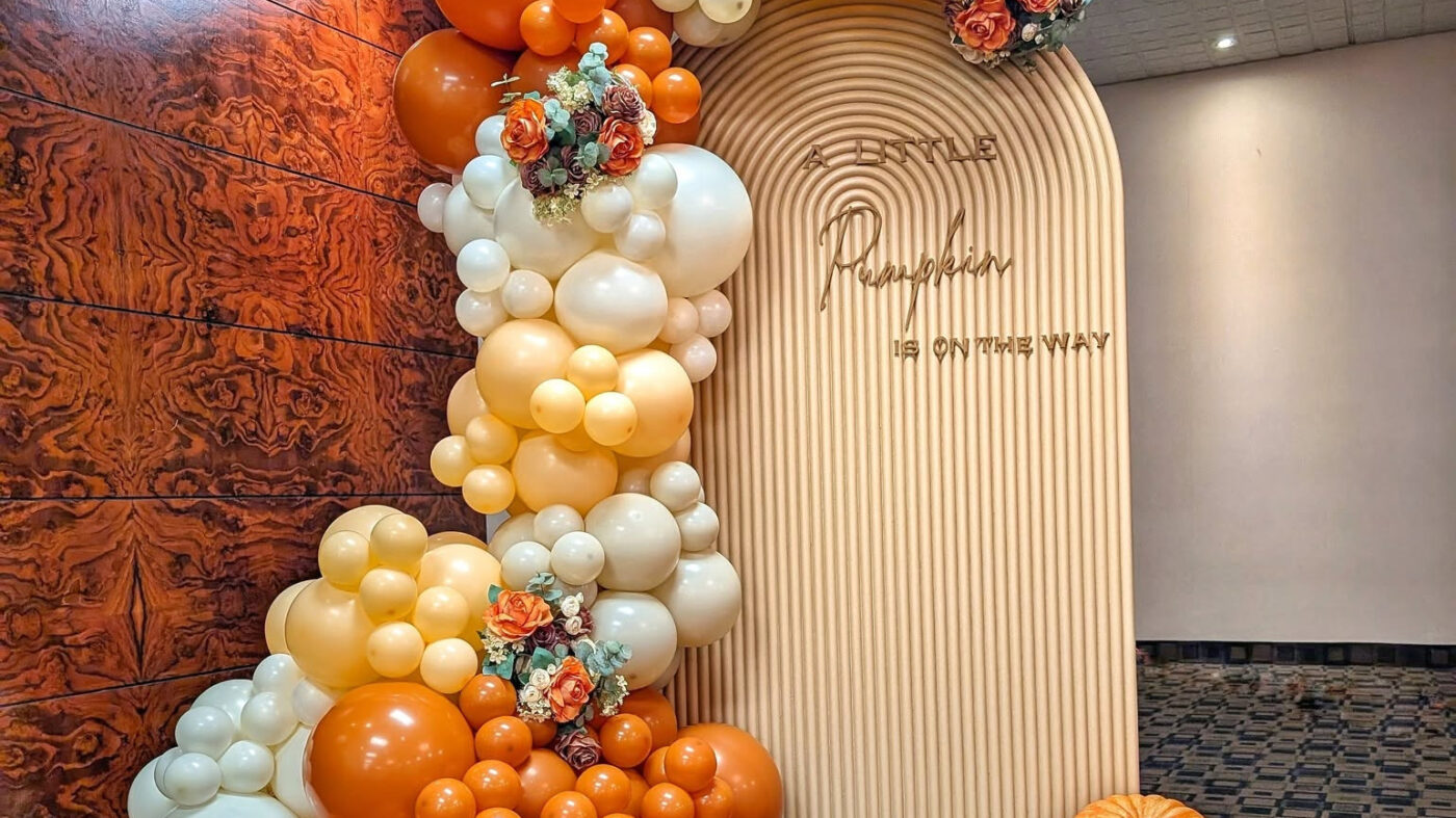 Elegant pumpkin baby shower backdrop with fall balloons, faux florals and pumpkins in Kitchener.