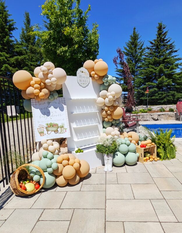 White champagne wall styled with organic balloons, produce baskets and garden greenery in Guelph.