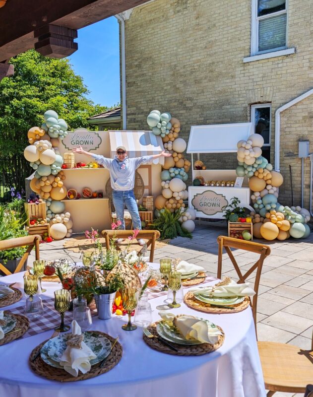 Layered garden tablescape with the Locally Grown farmers’ market display visible in the backyard.