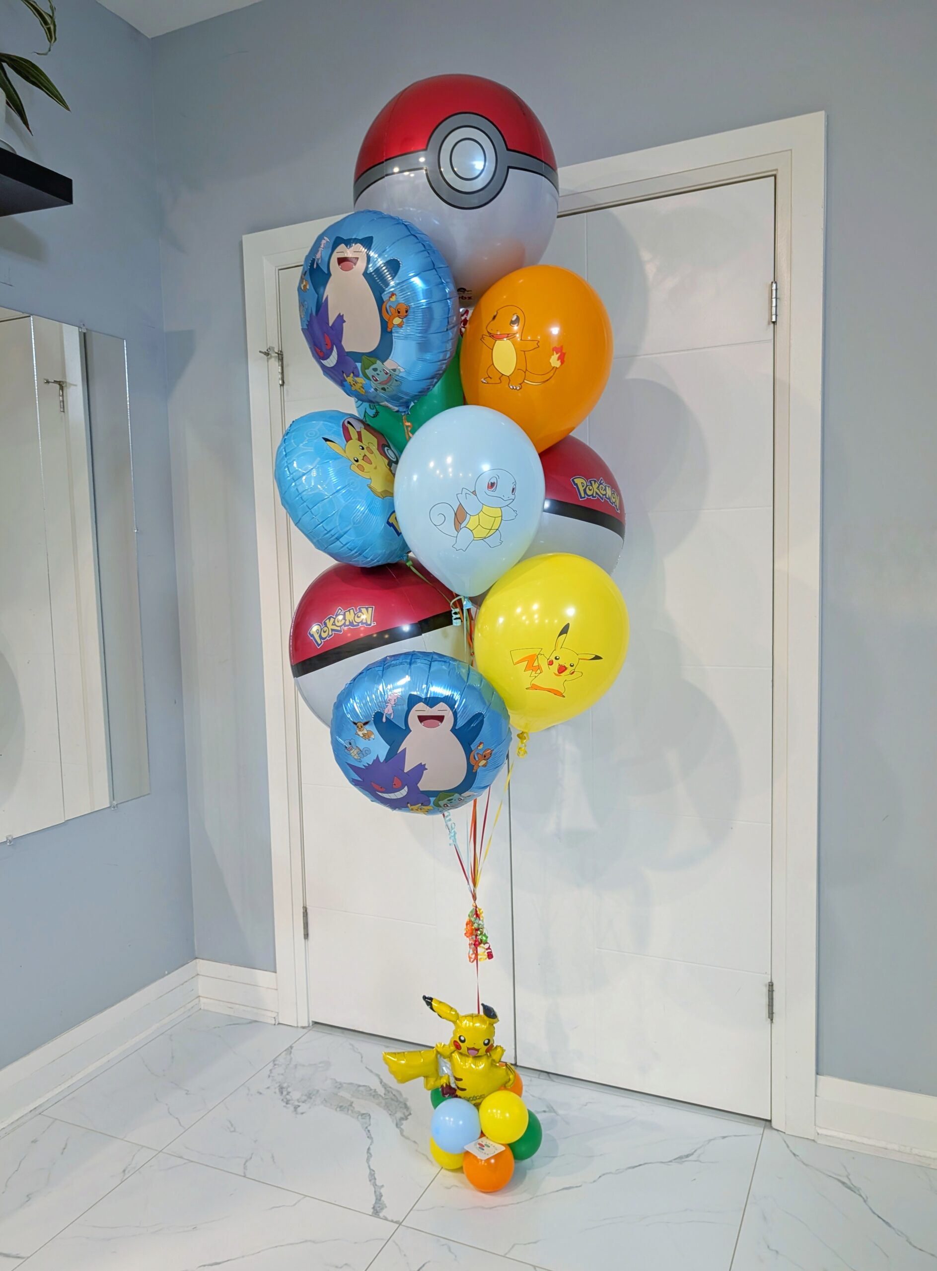 Pokémon helium balloon bouquet with Poké Balls, Pikachu, Snorlax, Charmander, Squirtle, and a colourful balloon base.