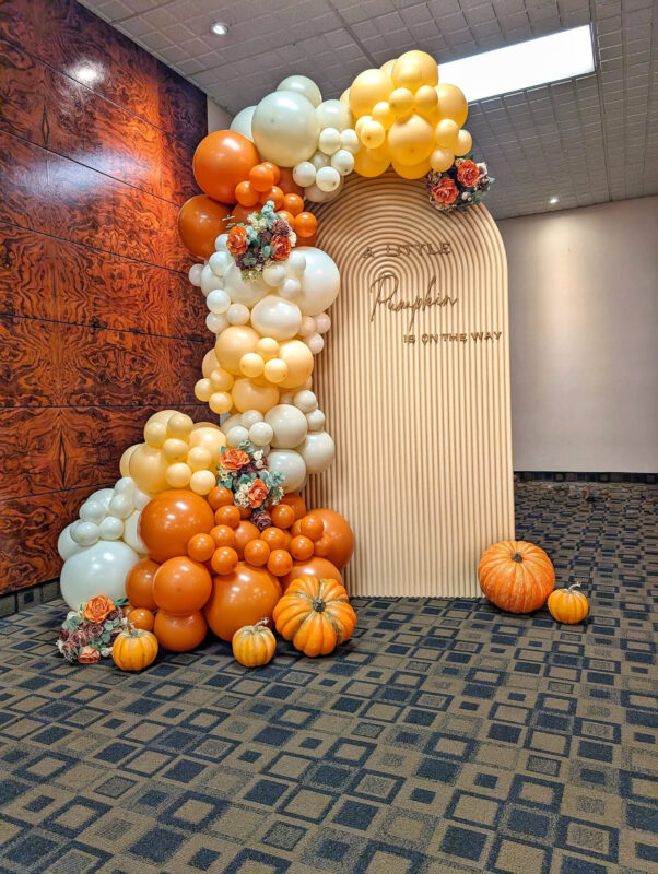 Ripple arch back drop with 3D printed sign and balloons and fall florals.