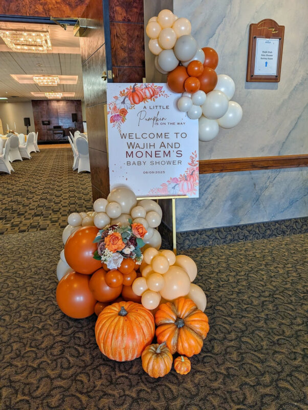 Personalized pumpkin baby shower welcome sign with balloons, faux florals and pumpkins at Bingemans.