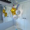 Birthday balloon bouquet with a colourful cake balloon, sprinkle birthday foils, and metallic gold stars.