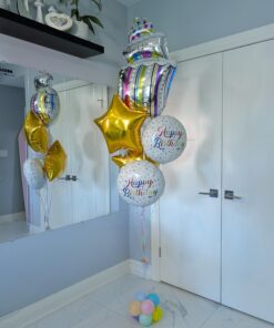 Birthday balloon bouquet with a colourful cake balloon, sprinkle birthday foils, and metallic gold stars.