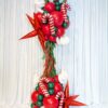 Red, green and white Christmas balloon column with candy canes, metallic stars, fringe and a festive foil topper.