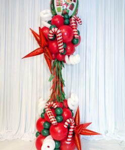 Red, green and white Christmas balloon column with candy canes, metallic stars, fringe and a festive foil topper.