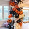 Halloween balloon garland with black spiders, jack-o’-lanterns, cobwebs, skeleton décor and orange, black and purple balloons.