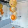 Peach-themed jumbo balloon bouquet with orange, cream, and neutral latex balloons.