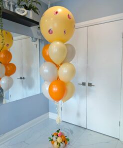 Peach-themed jumbo balloon bouquet with orange, cream, and neutral latex balloons.