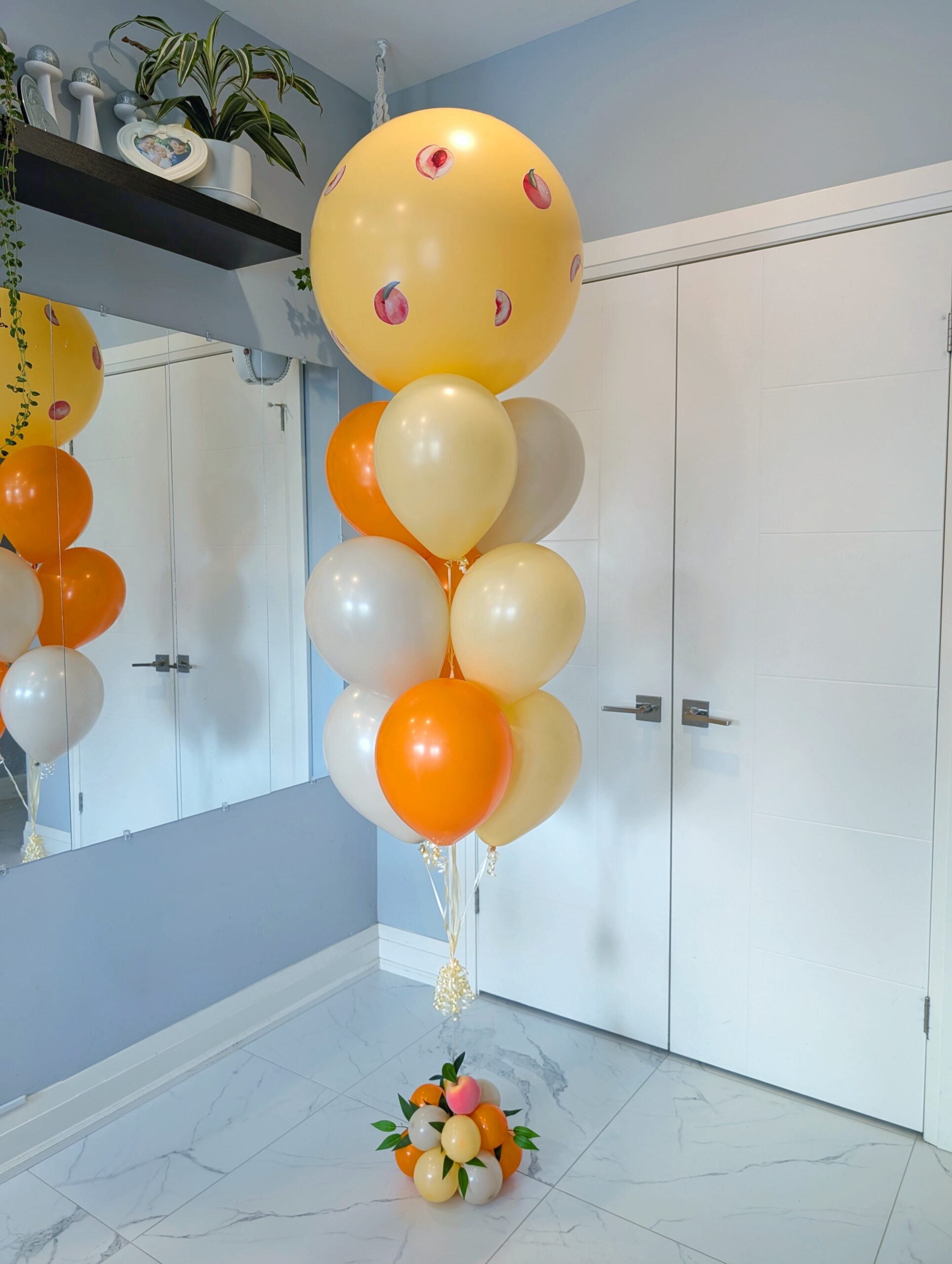 Peach-themed jumbo balloon bouquet with orange, cream, and neutral latex balloons.