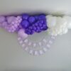 Lavender, purple and white organic anniversary balloon garland displayed above a personalized anniversary banner.