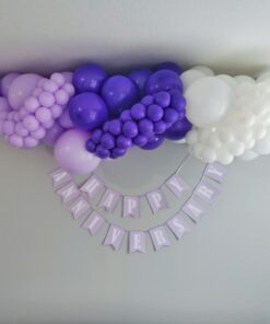 Lavender, purple and white organic anniversary balloon garland displayed above a personalized anniversary banner.