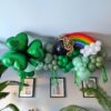 Green St. Patrickās Day balloon garland with shamrock, rainbow, pot of gold, white clouds and green fringe.