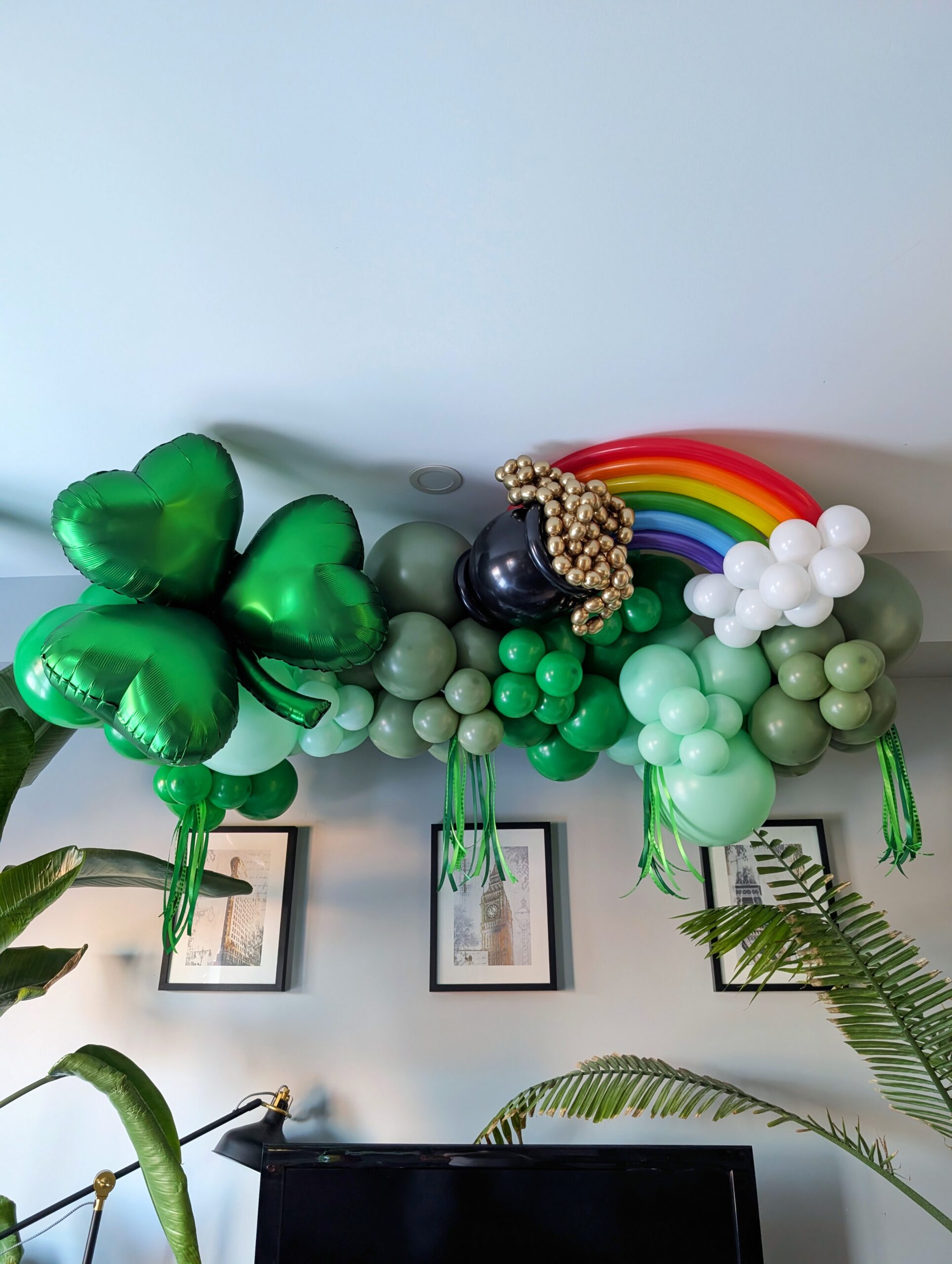 Green St. Patrick’s Day balloon garland with shamrock, rainbow, pot of gold, white clouds and green fringe.