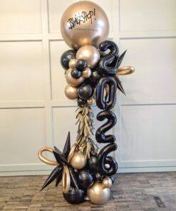 Black and gold New Year balloon column with 2026 numerals, starbursts, fringe and a custom branded topper.