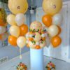 Peach farewell balloon combo with jumbo helium bouquets, orange and ivory balloons, greenery and personalized table topper.