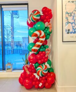 Red and green Christmas balloon column with oversized peppermint candies and striped candy cane balloons.