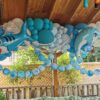 Blue under-the-sea balloon garland with shark and dolphin balloons, white accents and decorative fishing netting.